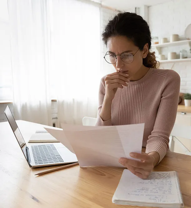 Professional woman analyzing financial documents at her desk, focused on accounting services and financial reporting in Dubai