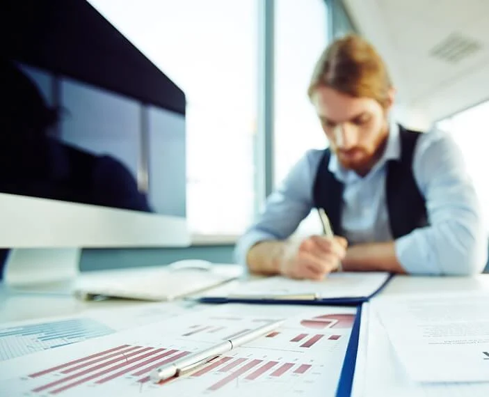 An employee working diligently on excise tax compliance, demonstrating the meticulous nature of tax consultancy services